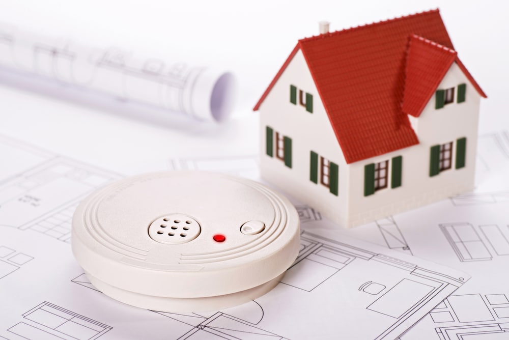 Smoke detector with house and blueprints — Electrician Sunshine Coast QLD