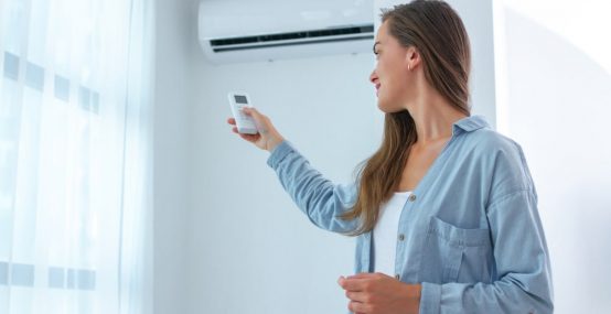 Young woman adjusts the temperature — Electricians in Warana QLD