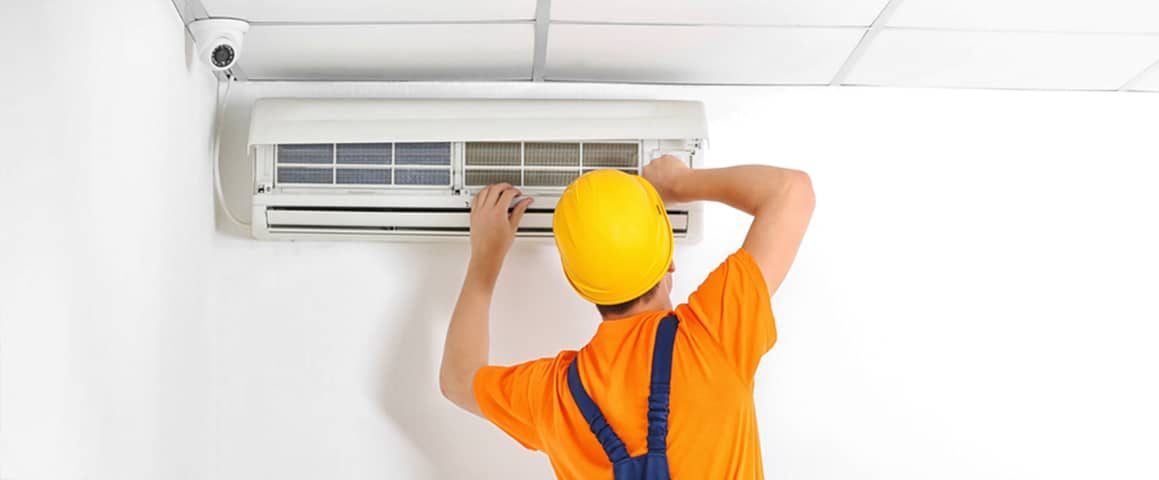 Technician repairing air conditioner on the wall — Air Conditioning in Maroochydore QLD