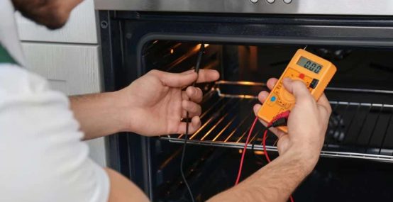 Electrician Using Multimeter On An Oven
